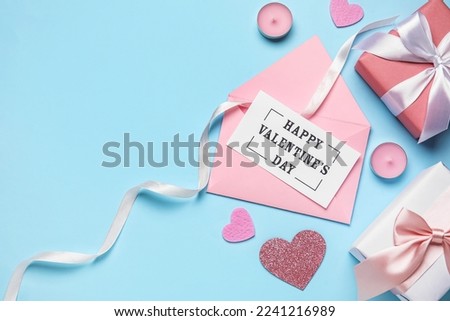 Letter with text HAPPY VALENTINE'S DAY, hearts, candles and gifts on blue background