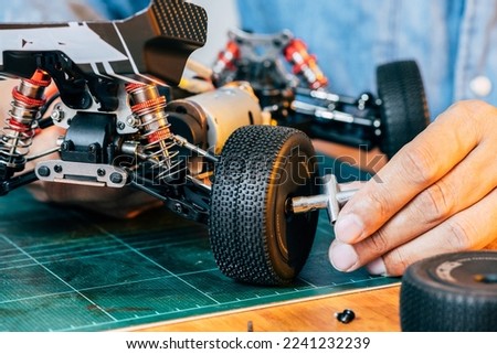 The man working on radio controlled buggy car. RC car assembly scene. Royalty-Free Stock Photo #2241232239