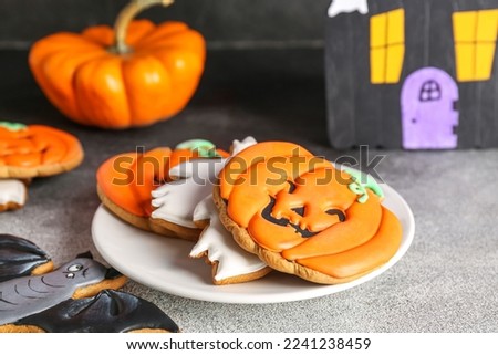 Plate with Halloween cookies on black and white background, closeup