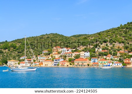 Yacht boat on sea with colorful houses of Vathi town in background, Ithaka island, Greece 
