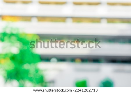 Defocused abstract background of a building with few plants in the frame. Blurred out building area background