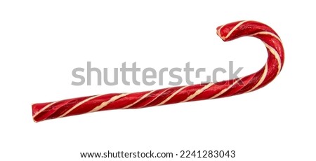 Hard candy stick in the form of a cane on a white background. Festive red caramel