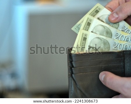 Close-up shot of 2000 Serbian dinar banknotes. A person takes money out of a wallet Royalty-Free Stock Photo #2241308673