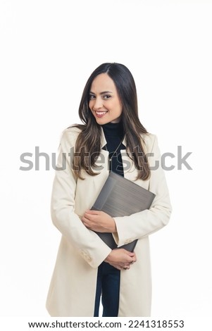 Modern latin american fashionable businesswoman standing holding document file with both hands looking into camera with friendly smile. Female manager. White background vertical studio shot. High