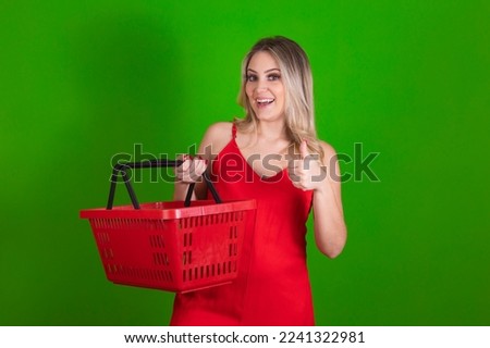 young woman with grocery basket in hands and thumb up making ok sign