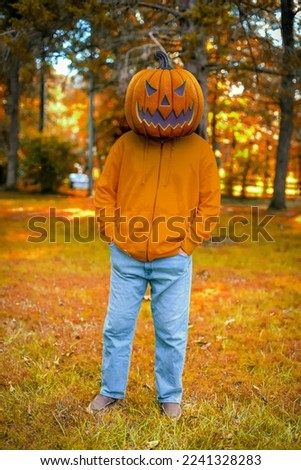 Man with pumpkin on his head in fall