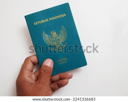 Human hand holding green pasport of republic indonesia isolated on white. Royalty-Free Stock Photo #2241336683