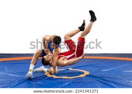 The concept of fair wrestling. Two greco-roman  wrestlers in red and blue uniform wrestling   on a wrestling carpet