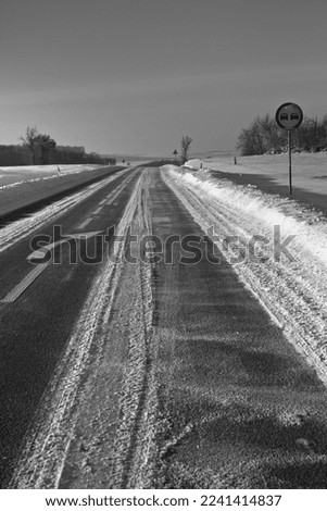 Winter road. Winter landscape of winding road. Snowy winter on the countryside, black and white picture. Highway leading through snowy fields. Drifts on the road.
Snowy road  of panoramic landscape.
