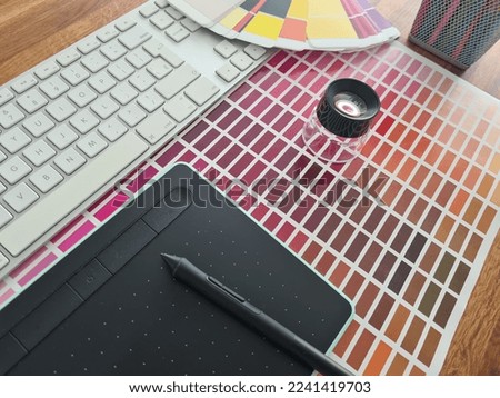 Color palette catalog of samples of paints and shades. Designer items lie on keyboard