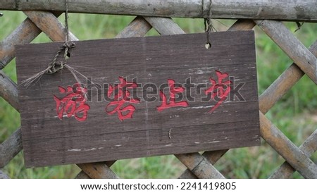 A wooden warning sign written four Chinese characters which means visitors not admitted. 