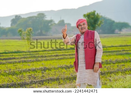 Indian farmer showing thumps up at agriculture field. Royalty-Free Stock Photo #2241442471
