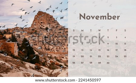 2023 Calendar with a Cappadocia photo in the background. The photo has an old stone castle, pigeons, a blue sky, and brown fairy chimneys. November.
