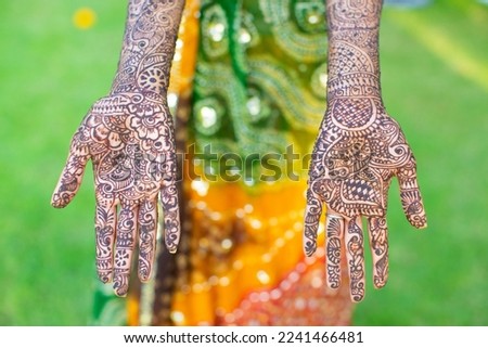 Henna designs on the hands of an Indian bride, a beautiful pattern unique to the national art of India on her left and right hand, looks very beautiful