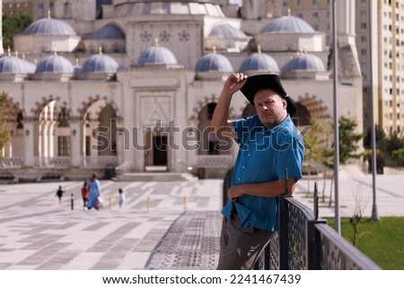 Adult man walking and posing in the city street on a sunny summer day