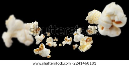 Flying popcorn, isolated on black background Royalty-Free Stock Photo #2241468181