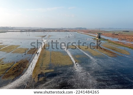 Aerial from ice skating at the Ypey windmill in Friesland the Netherlands in winter