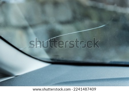Defective windshield from falling rocks - crack in the safety glass Royalty-Free Stock Photo #2241487409
