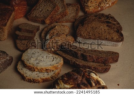 Bread, traditional sourdough bread, cut into slices on a rustic craftpaper background. The concept of traditional ways of baking yeast bread. Background for advertising