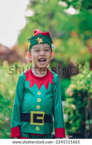 Smile Cute Asian boy in elf's costume in green nature garden outdoor background in evening lighting
