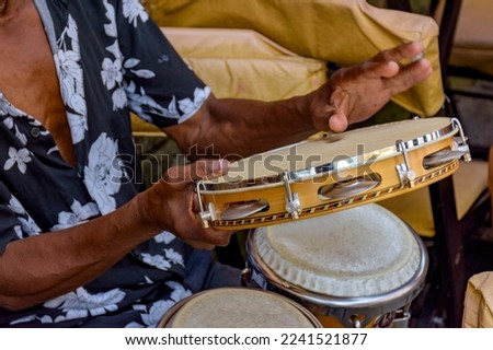Detail of musician playing tambourine in the streets of Pelourinho in Salvador in Bahia during a samba performance at Carnival Royalty-Free Stock Photo #2241521877