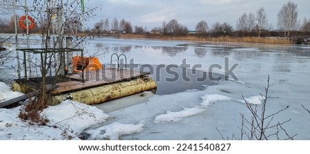 A hole cut in a frozen pond. The hole is equipped with a staircase