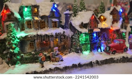 A small miniature Christmas village, with snow, figurines or people, artisan houses, ski resort, ice rink, craft decoration, model, fir trees and festive atmosphere, attraction and fun