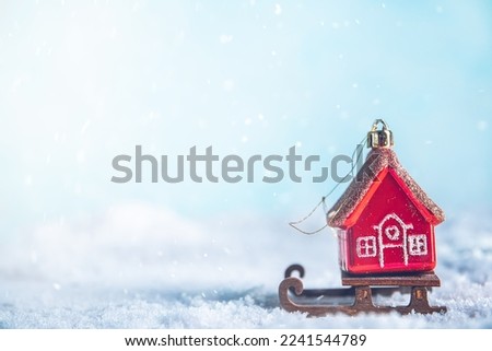 Christmas tree toy in the form of a red house on a sleigh in the snow. christmas, new year background, with copy space, concept House insurance, house gift