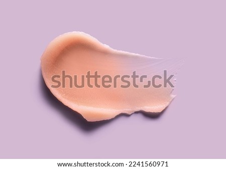 Cosmetic lip balm, salt or sugar scrub orange swatch on purple background Royalty-Free Stock Photo #2241560971