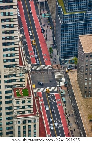 Looking down on New York City intersection with red and black lanes and lined with skyscrapers