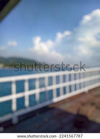 Blurred background view of sea, island and blue sky with white clouds during sunny day. Picture taken from the bridge