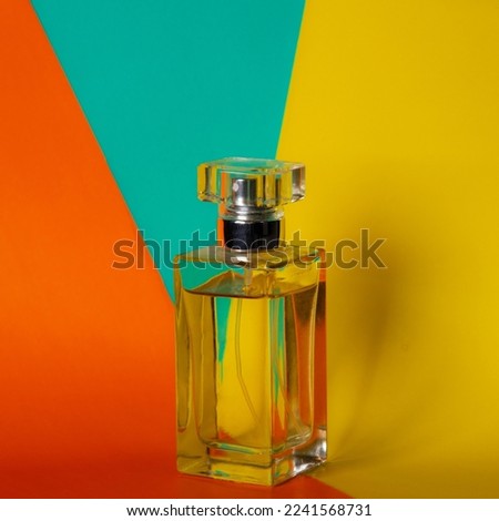 A perfume bottle with a colorful background.