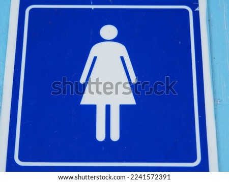 The image shows the sign indicating that male and female restrooms are separated, made of blue acrylic. The image shows shallow depth.