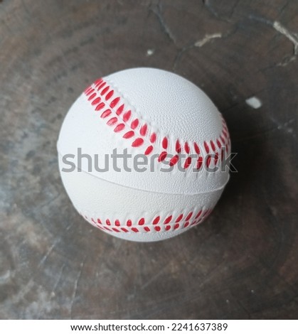 Baseball or softball ball on the ground. Plays it by the kids. Miniatur or toys.