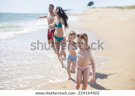 happy family in swimsuit having fun in the beach
