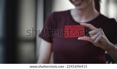 Woman holding blank business card or credit card. Red Paper Card for Mockup
