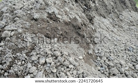 Detail the surface texture with small pebbles on the dirty ground. Natural rough sand. For construction background or wallpaper