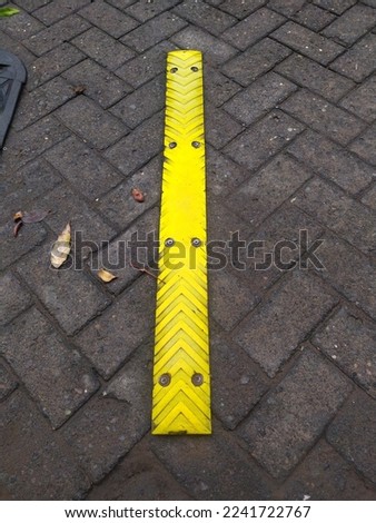 Yellow Speed Bump on paving block