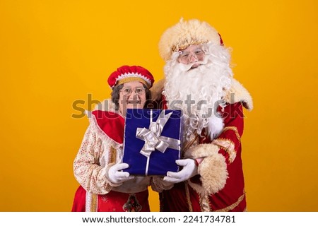 Real Santa Claus and Mama Claus holding a gift box