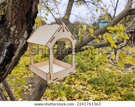wooden bird feeder in autumn garden, nature conservation concept