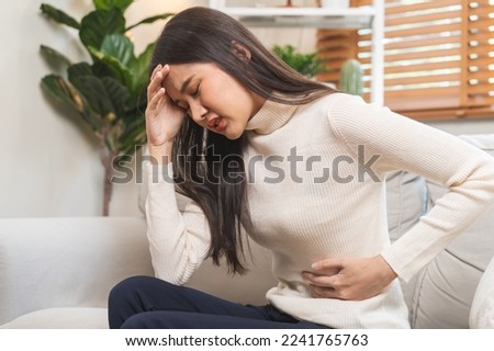 Flatulence asian young woman, girl hand in stomach ache, suffer from food poisoning, abdominal pain and colon problem, gastritis or diarrhoea. Patient belly, abdomen or inflammation, concept. Royalty-Free Stock Photo #2241765763