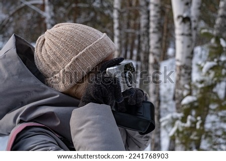 girl in winter park taking pictures