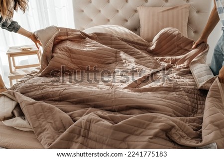make the bed. Soft folded blanket and pillows on bed indoors. cleaning Ironing and hotel service concept.
