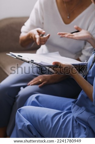 Homecare nursing service and elderly people cardiology healthcare. Close up of young hispanic female doctor nurse check mature caucasian  patient heartbeat using stethoscope during visit
