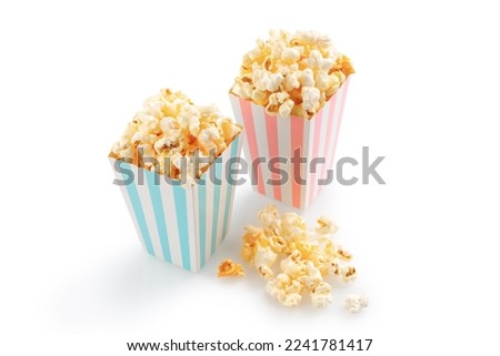 Two pink and blue striped carton buckets with tasty cheese popcorn, isolated on white background. Movies, cinema and entertainment concept.