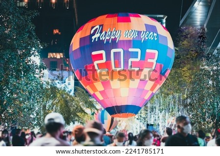 Organizing the New Year 2023 festival celebration. Write the word Happy New Year 2023 on the balloon and celebrating new year eve.
