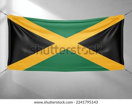 Jamaica national flag cloth fabric waving on beautiful grey sky.