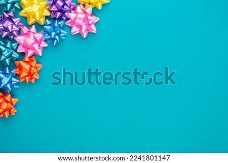 Blue background for birthday party with colorful stars. Present with copy space. Top view.