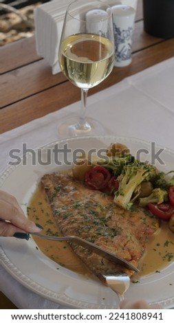 Fish dinner and a glass of wine at the restaurant by the sea