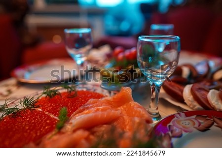 Russian New Year's table. Red fish, caviar and glasses for vodka.